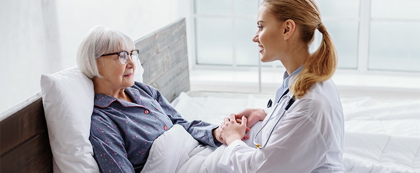 A nurse holding the hand of a patient.