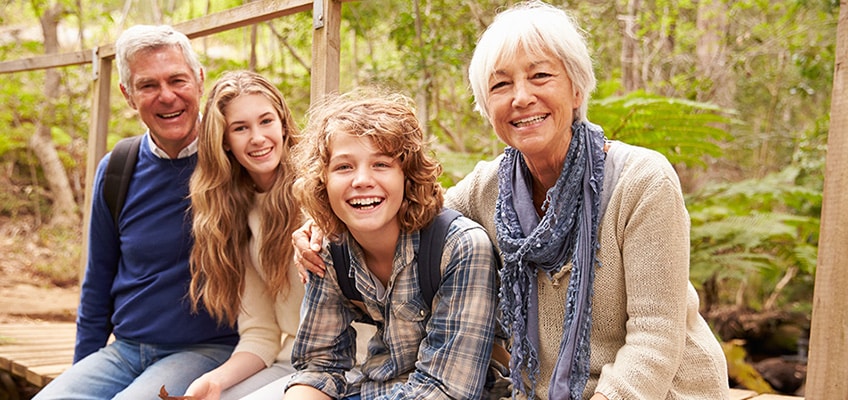 A couple sitting outside with grandkids.