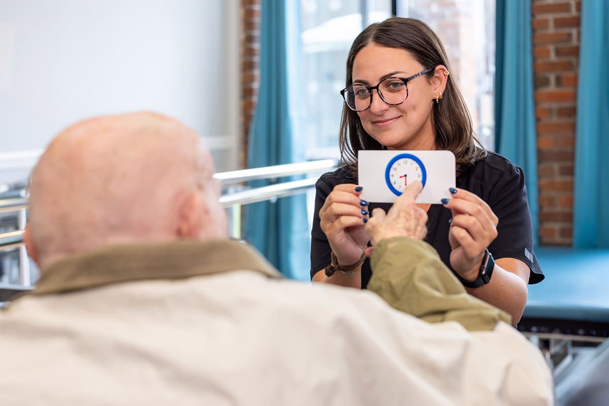 Occupational therapist holding flash card for patient at Johns Island Post Acute