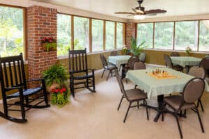 Screened in porch with tables at Johns Island Post Acute
